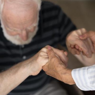 A carer assisting an elderly man.