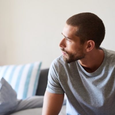 Man sitting pensively on his bed