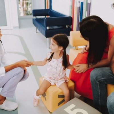 Smiling doctor handshaking child