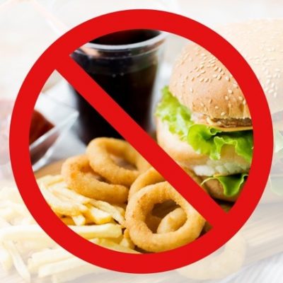 Prohibited sign over an image of typical fast food.