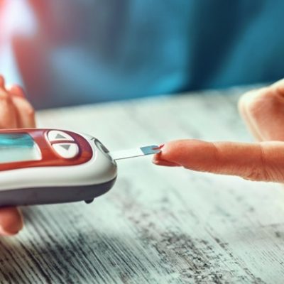 Diabetic woman using blood glucose meter