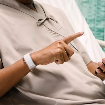 Patient touching his smartphone in hospital