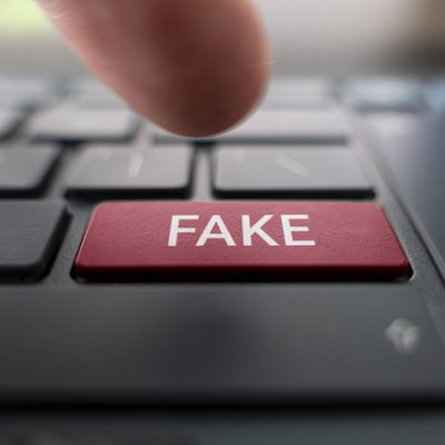 Red button on keyboard with Fake written on it.