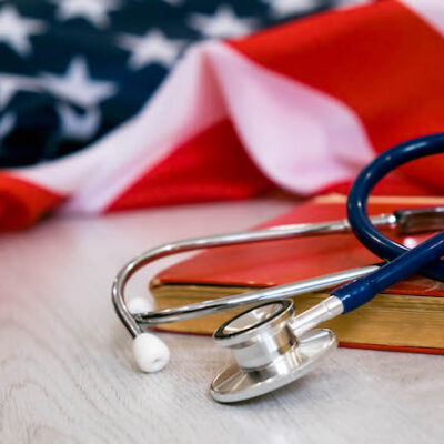 Stethoscope, book, and US flag.