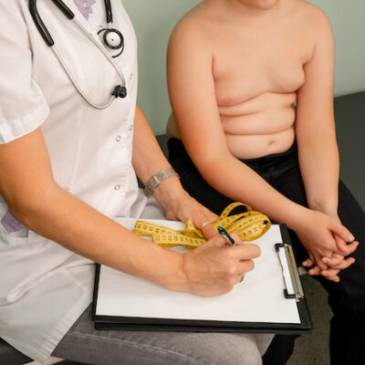Boy sitting next to doctor.