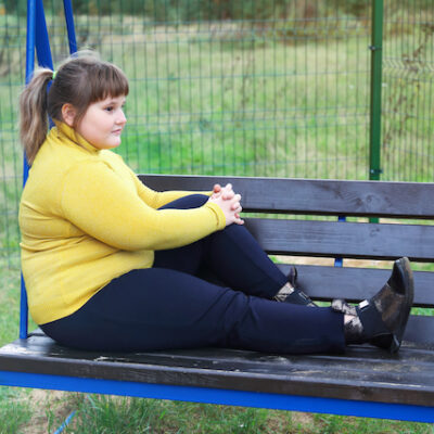 Girl in thought on a park bench.
