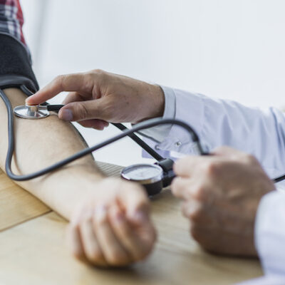 Doctor taking a man's blood pressure.