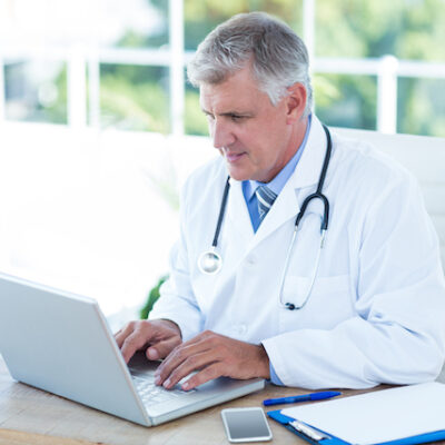 Doctor working on laptop at his desk