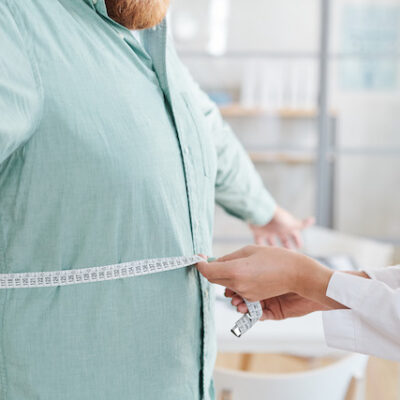 Doctor measuring man's stomach.