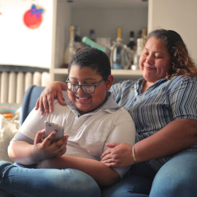Mother and son on the sofa use a smartphone