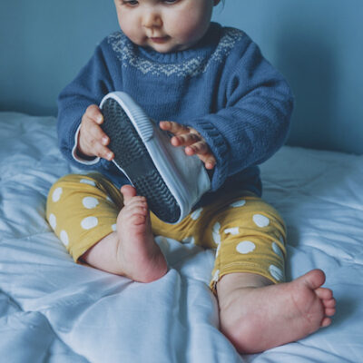 Little baby playing with a sneaker
