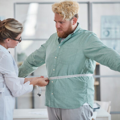 Doctor measuring a patient's waist.