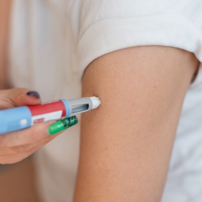 Woman using an obesity medication pen.