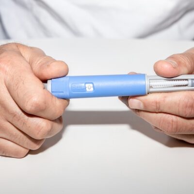 A man holding an Ozempic medication pen.