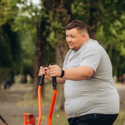 Man with obesity exercising outdoors.