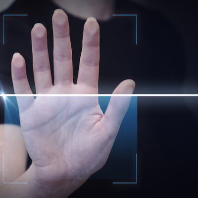 A person having their palm scanned with technology.