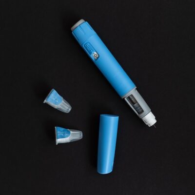 An Ozempic pen on a black background.