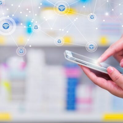 Pharmacist using a smartphone in a pharmacy.
