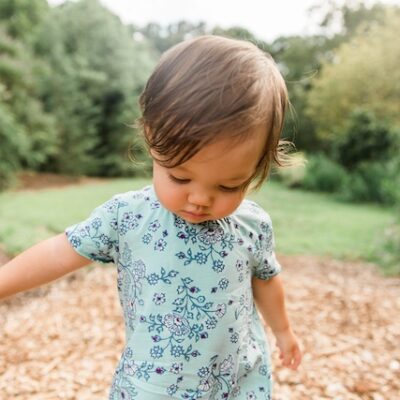 Two year old girl standing outdoors.