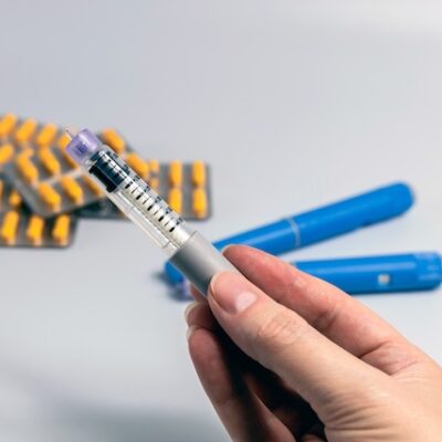 Hand holding and Ozempic pen.