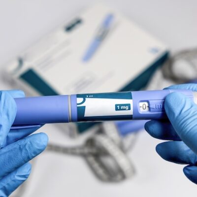 Healthcare professional holding a GLP-1 pen