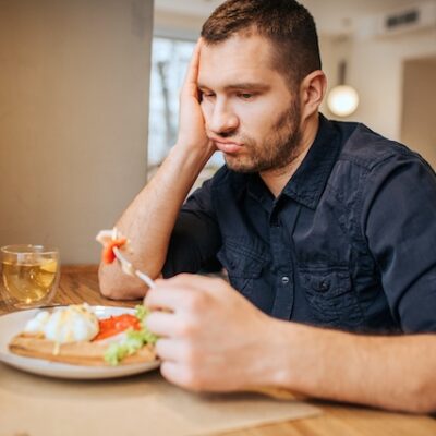 Sad man sitting at table in a cafe.