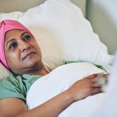 Woman patient with cancer in a hospital bed.