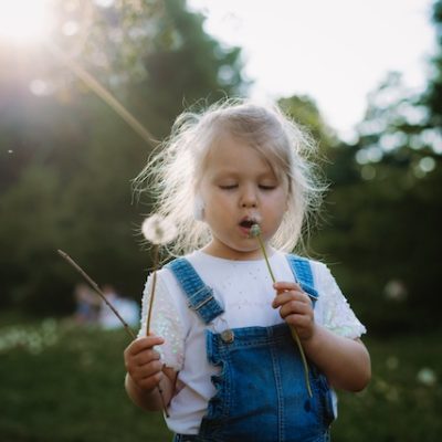 Little girl playing in a field.