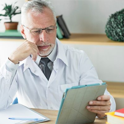 Healthcare professional in white coat reviewing clinical charts at office desk, representing the workforce preparation challenges in obesity care