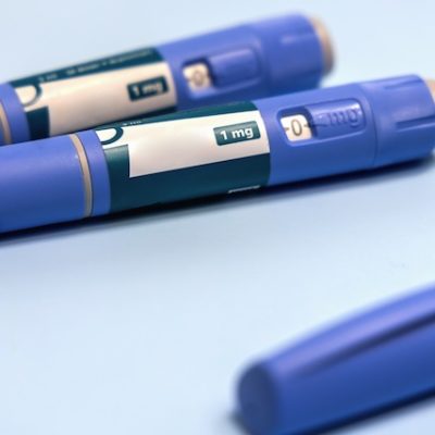 Ozempic pens on a light blue background.