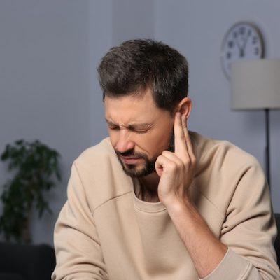 Man suffering from ear pain.