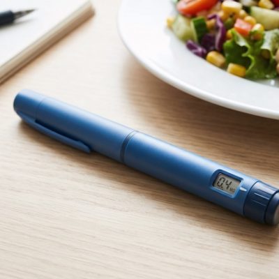 Ozempic pen and food on a table.