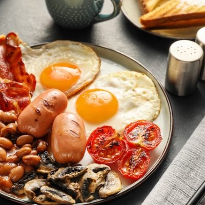 Big breakfast served on a plate on a restaurant table.