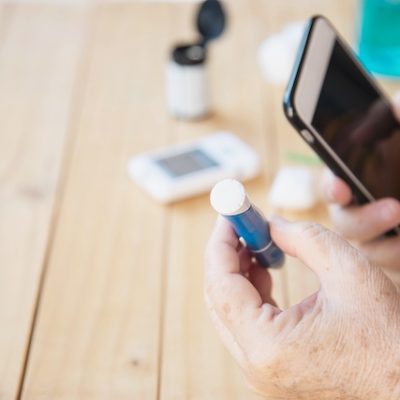 Old lady testing her blood sugar level.