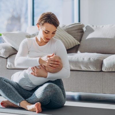 Young woman breast feeding toddler son.