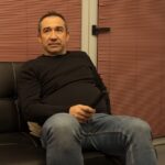Man watching television relaxing on sofa with remote control.