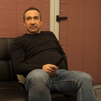 Man watching television relaxing on sofa with remote control.