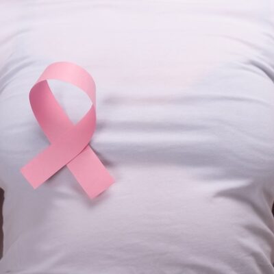 Woman wearing a pink ribbon on her breast.