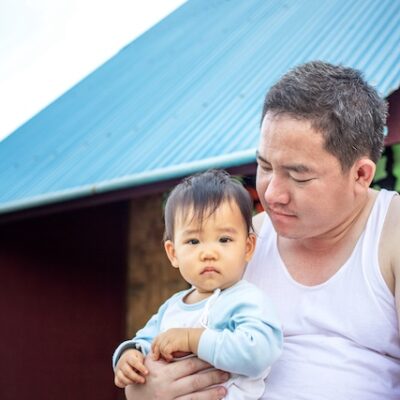Father and baby daughter sitting outside together.