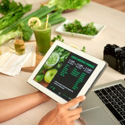 Woman reading green smoothie formula on a tablet.