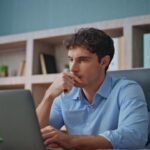 Man at his computer deep in thought.