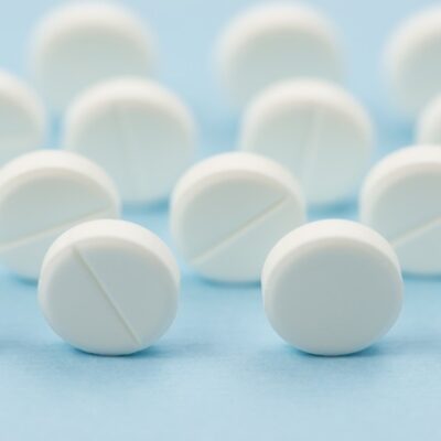 Assortment of pills on a light blue background.