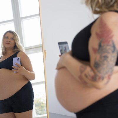 Portrait of a pregnant woman with obesity taking a selfie.
