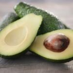 Fresh avocados on wooden background.