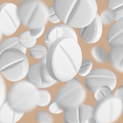 White pills on an orange background.