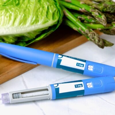 Ozempic pens and a chopping board with vegetables on top of it.