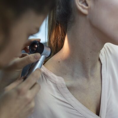Dermatologist examining patient.